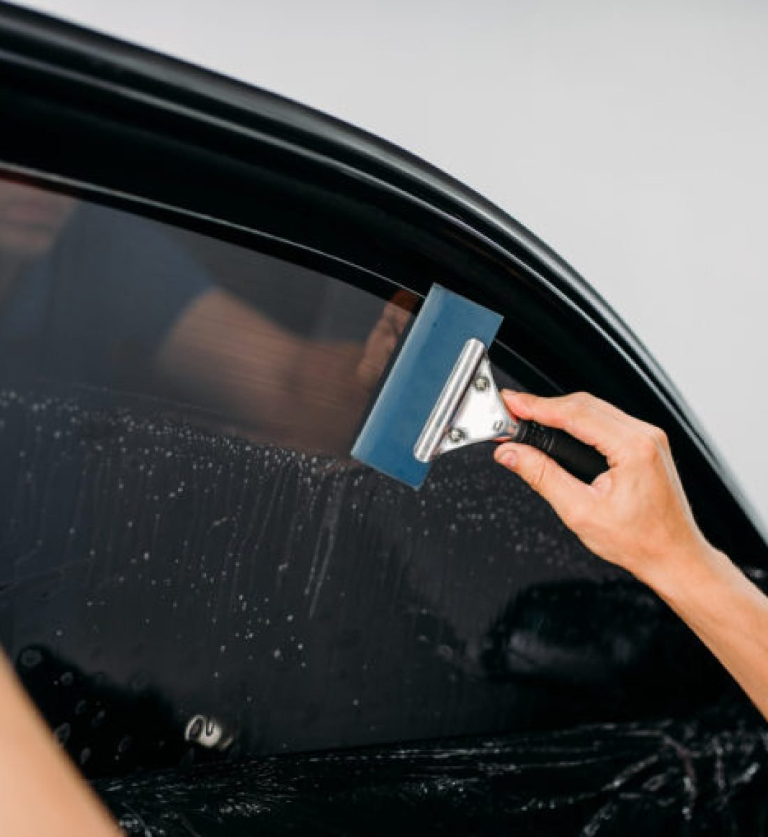 man-using-squeegee-on-car-window-AdobeStock_178562910-762x508